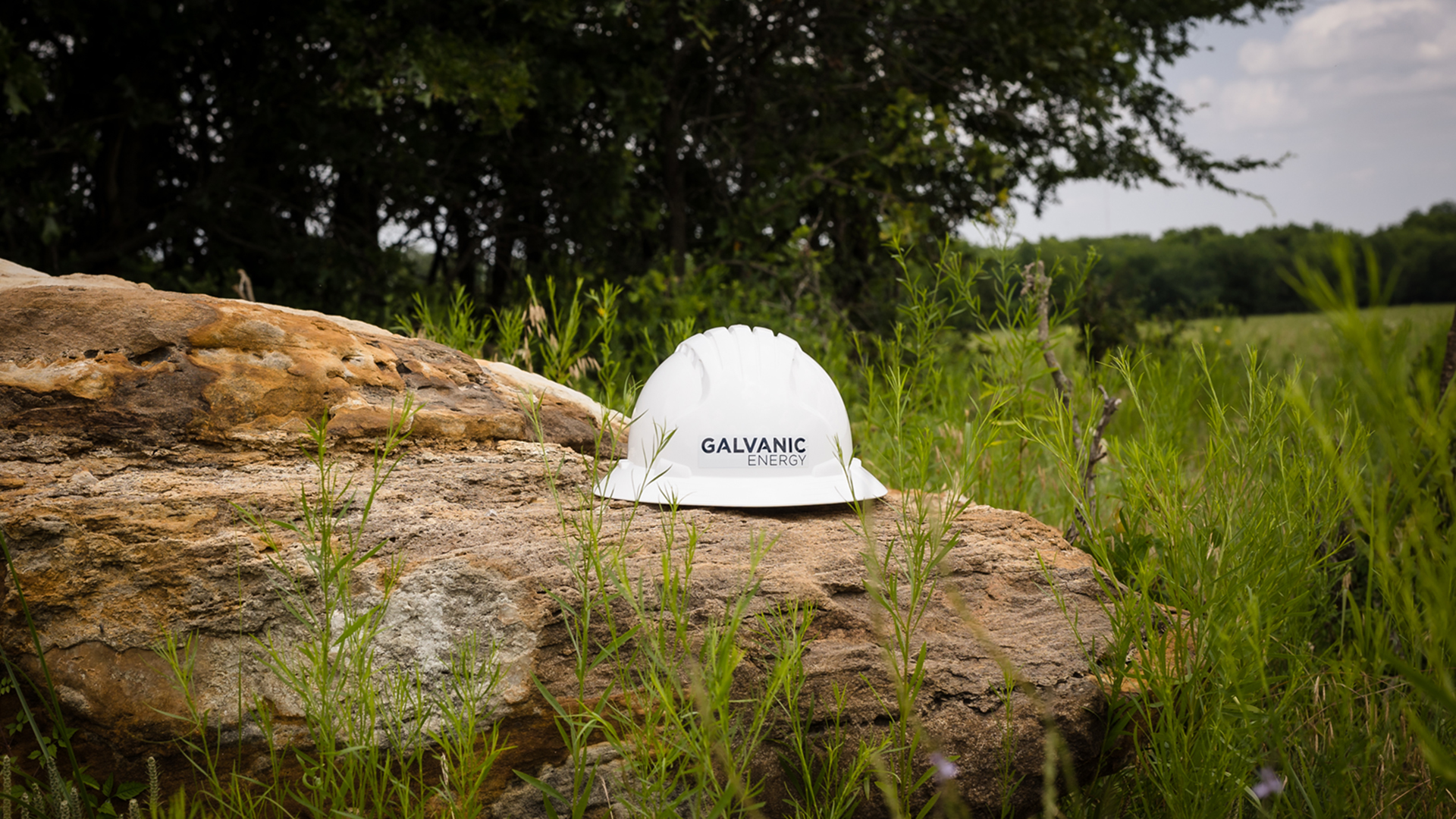 Galvanic Energy hard hat resting on a rock